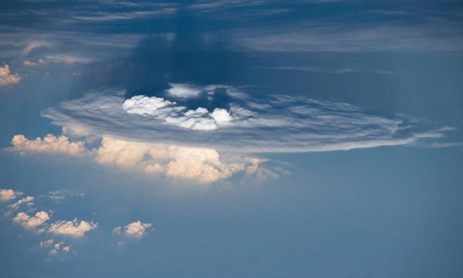 The cauliflower-like formations above the flat part of this cumulonimbus cloud represent overshooting cloud tops, which occur when forces push the clouds up through the troposphere, the lowest region of the atmosphere, and into the stratosphere. The warm central Pacific Ocean sea surface during the 2015-2016 El Niño lofted abnormal amounts of cloud ice and water vapor into the stratosphere, creating conditions similar to those that could occur on a larger scale in a warming world. Photo: NASA/ESA