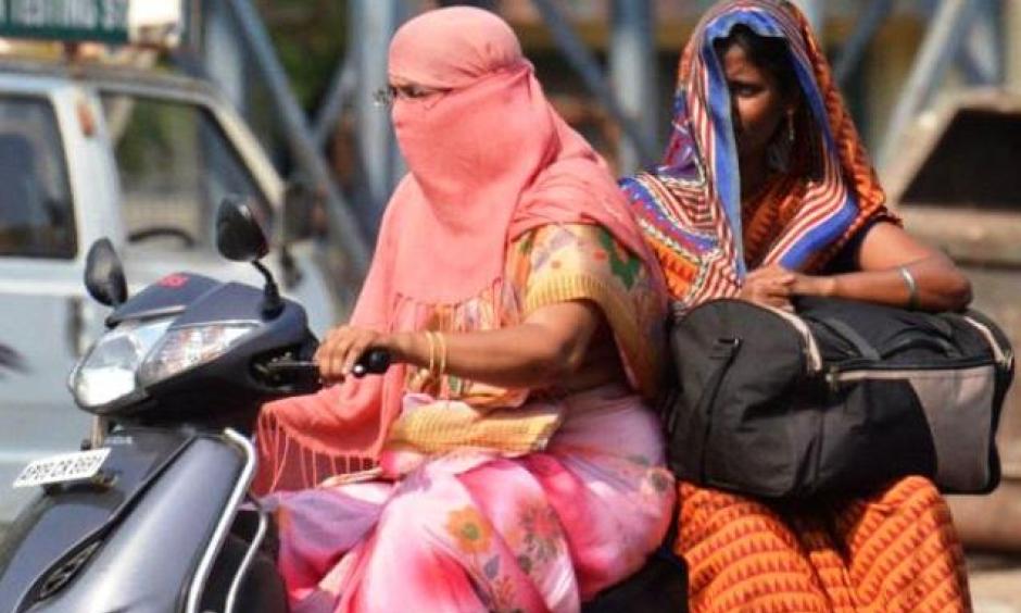 Covering their faces with a scarf and the saree's pallu, these women are trying their best to beat the heat in Vijayawada, in this April 5 picture. Photo: V. Raju, The Hindu
