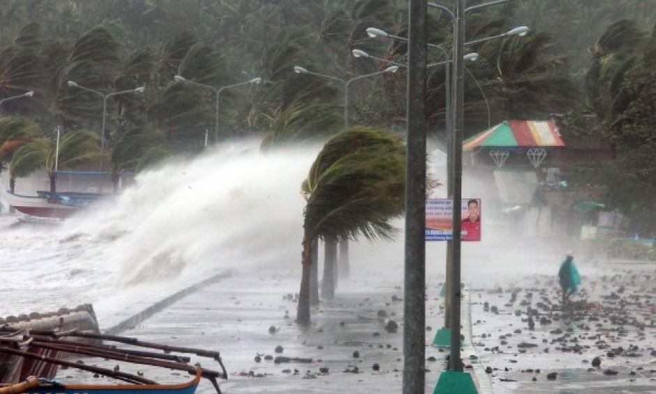 A resident walks past high waves pounding the seawall amid strong winds as Typhoon Haiyan hit the city of Legazpi, Albay province, Philippines, on Nov. 8, 2013. Photo: Charism Sayat, AFP, Getty Images