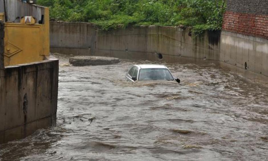Photo: A car floating in a nala at Qutbllapur village, following heavy rain on the outskirts of Hyderabad on Wednesday. Photo: G. Ramakrishna
