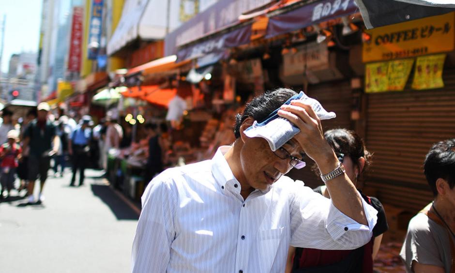 People walk in the street during a hot day in Tokyo's district of Ueno on August 7. Credit: Charly Triballeau, AFP Getty