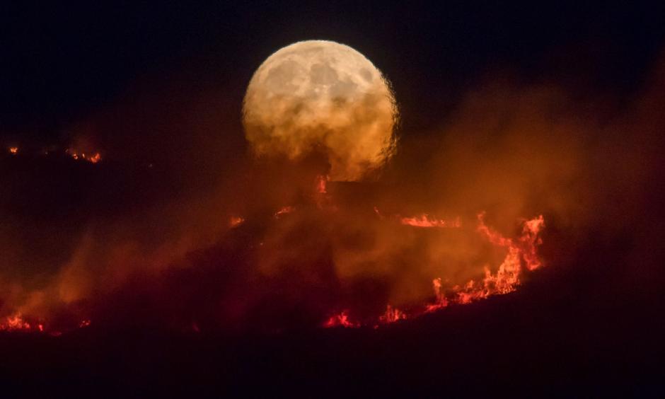 The full moon rises over the Saddleworth Moor fire. Photo: Getty