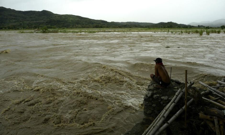 A man looks at the rising water level of the Magat River caused by continuous rains of Typhoon Koppu at Bayombong, Nueva Viscaya, Philippines, on Sunday, October 18, 2015. Koppu wrecked houses, tore down trees, and unleashed landslides and floods, forcing thousands to flee as it pummeled the northern Philippines on Sunday. Image credit: STR/AFP/Getty Images.