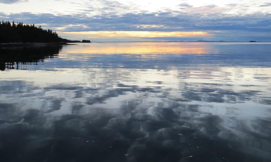 A sunset is visible aboard a schooner anchored off the coast of Isle au Haut in the Gulf of Maine. Photo: Becky Krystal, The Washington Post