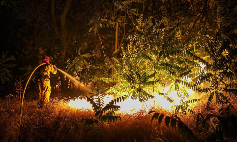 A firefighter works to defend structures on Lytle Creek Road on Wednesday night. Photo: Marcus Yam / Los Angeles Times