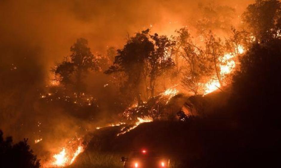 Flames from the Detwiller fire spread down a hillside near Mariposa, California on July 17, 2017. Photo: Noah Berger, EPA