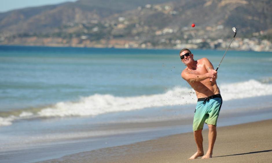 Dan Charcoal, who is vacationing in Southern California from Maui, golfs on Zuma Beach during a hot winter day Monday. Photo: Wally Skalij, Los Angeles Times