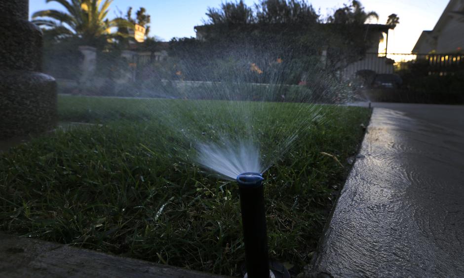 Sprinklers water a lawn at dusk in Beverly Hills. Statewide, Californians cut their urban water use in March by 24.3% compared with the same month in 2013, regulators said. Photo: LA Times