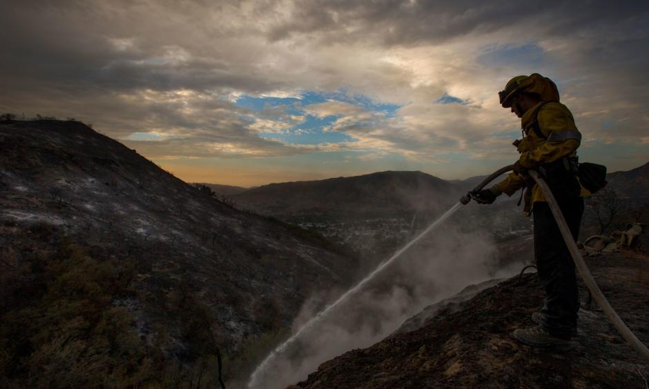 Los Angeles County firefighter Kevin Sleight extinguishes hot spots while battling the La Tuna fire. Photo: Allen J. Schaben / Los Angeles Times