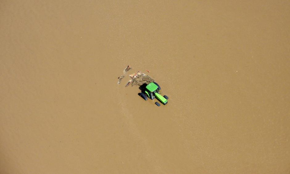 A tractor sits partially submerged in a field after flooding along the South Platte River in Weld County, Colorado near Greeley, on September 14, 2013. Photo: John Wark, AP