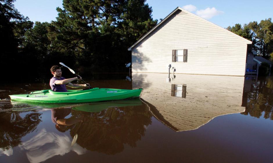 A resident paddles his kayak into his neighborhood to check the condition of his house as river levels rise into town in the aftermath of Hurricane Matthew, in Greenville, North Carolina, Oct. 14, 2016. Photo: Jonathan Drake, Reuters