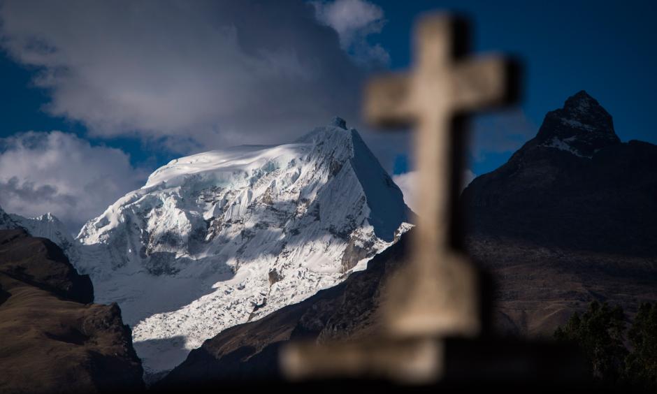 An Andes mountain range and a cross headstone are seen from Cementerio Municipal De Huaraz in Huaraz, in the Ancash region of Peru, on July 13. Photo: Jabin Botsford