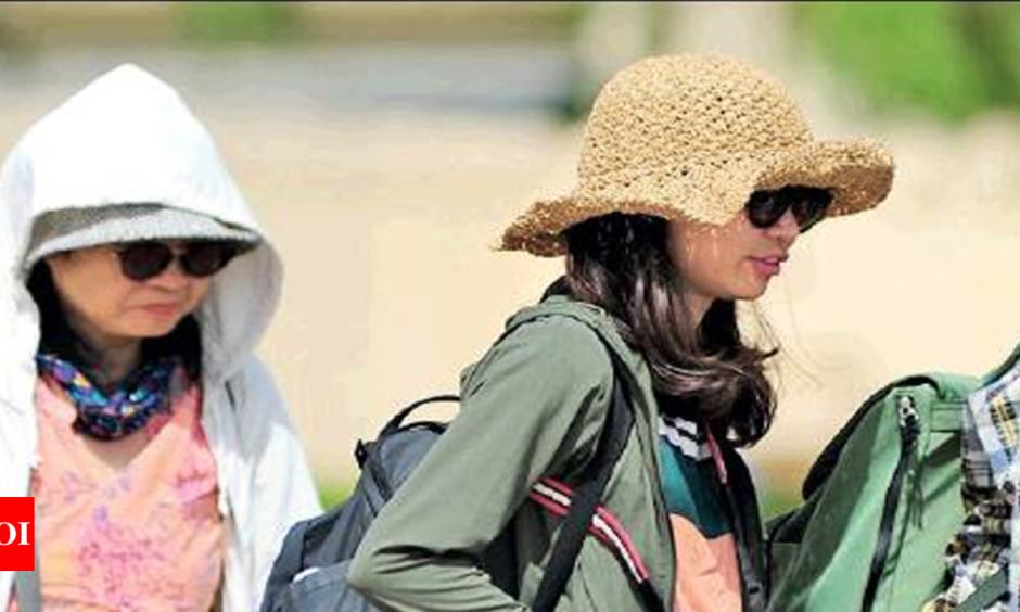 Tourists protect themselves from the heat. Photo: Times of India