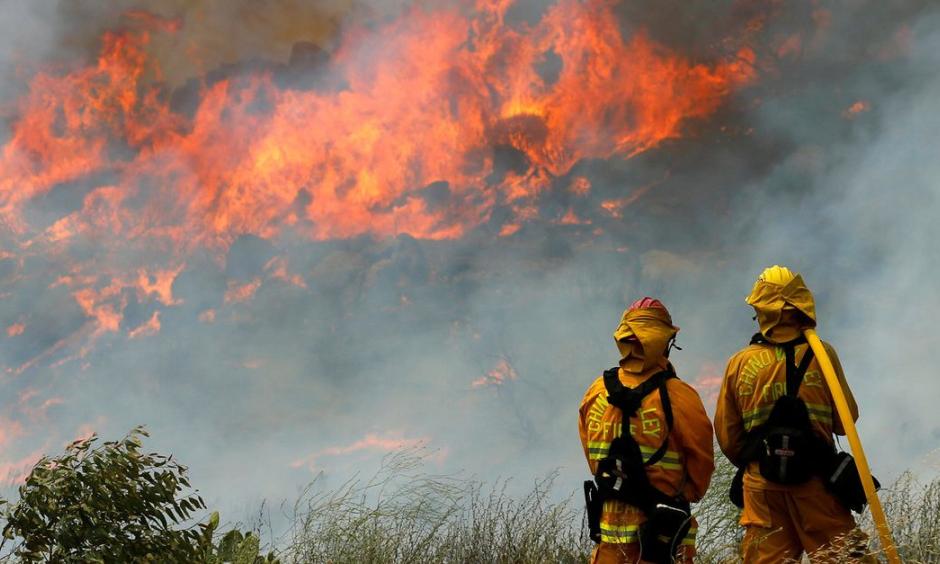 Helicopters sucked water out of a reservoir to drop on flames while air tankers bombarded the flanks of the fire with retardant. Photo: Mike Blake / Reuters