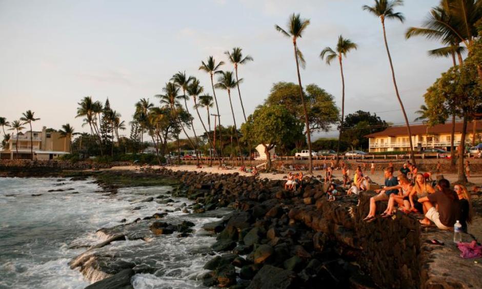 Tourists and locals watch the sunset from White Sands Beach Park in Kailua-Kona, on Hawaii's Big Island, January 31, 2016. Photo: Canice Leung, Reuters