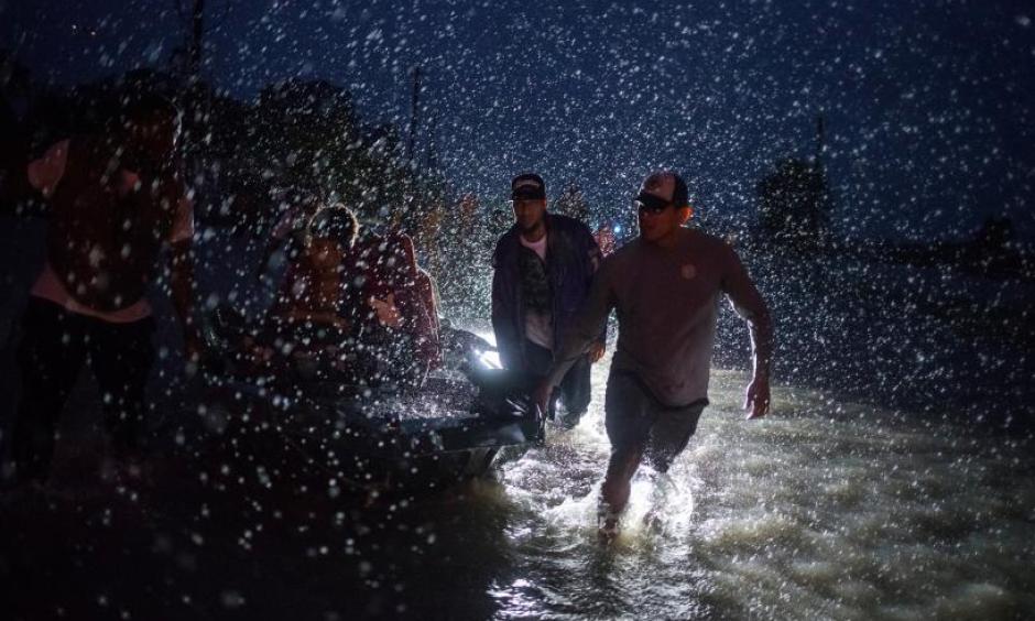 Samaritans help push a boat with evacuees to high ground during a rain storm caused by Tropical Storm Harvey along Tidwell Road in east Houston, Texas, U.S. August 28, 2017. Photo: Adrees Latif