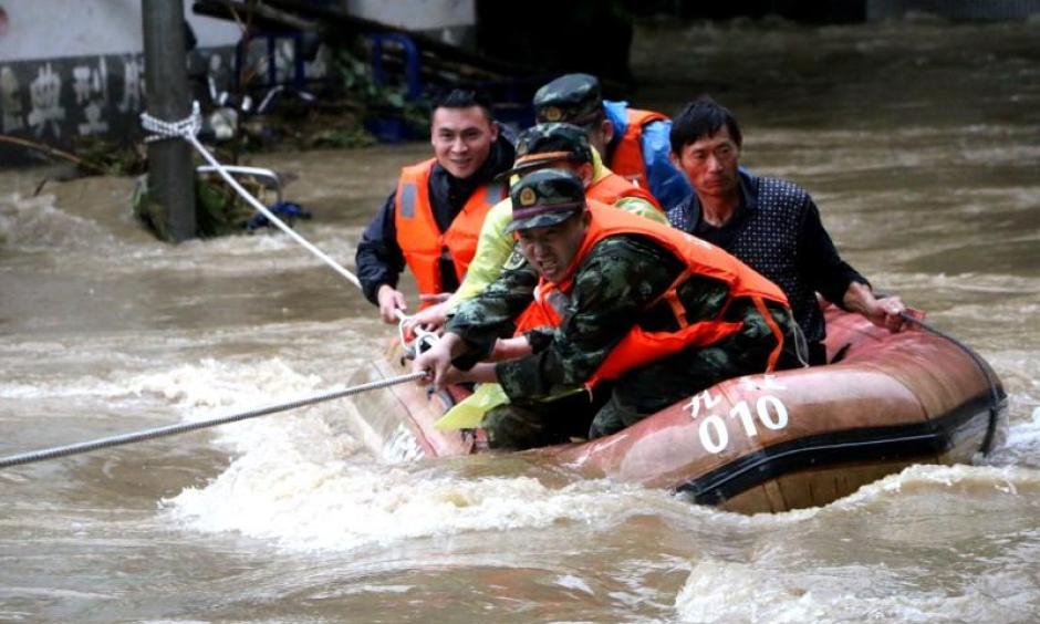 Rescuers grab a rope to prevent a raft carrying residents from being flushed away as residents are evacuated from a flooded area in Jiujiang, Jiangxi Province, China, June 19, 2016. Photo: Reuters / Stringer
