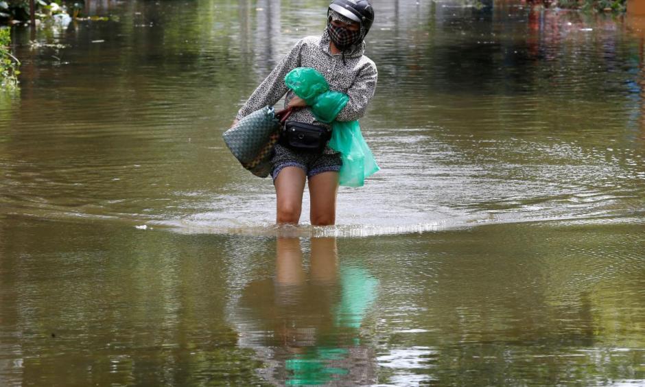 A woman wades through a flooded village after heavy rainfall caused by tropical storm Son Tinh in Ninh Binh province, Vietnam, July 22, 2018. Photo: Reuters/Kham