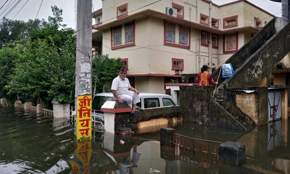 A man sits on a boundary wall of a house as he waits to be evacuated from a flood-affected neighbourhood in Patna, in the eastern state of Bihar, India, October 1, 2019. Photo: Reuters/Stringer