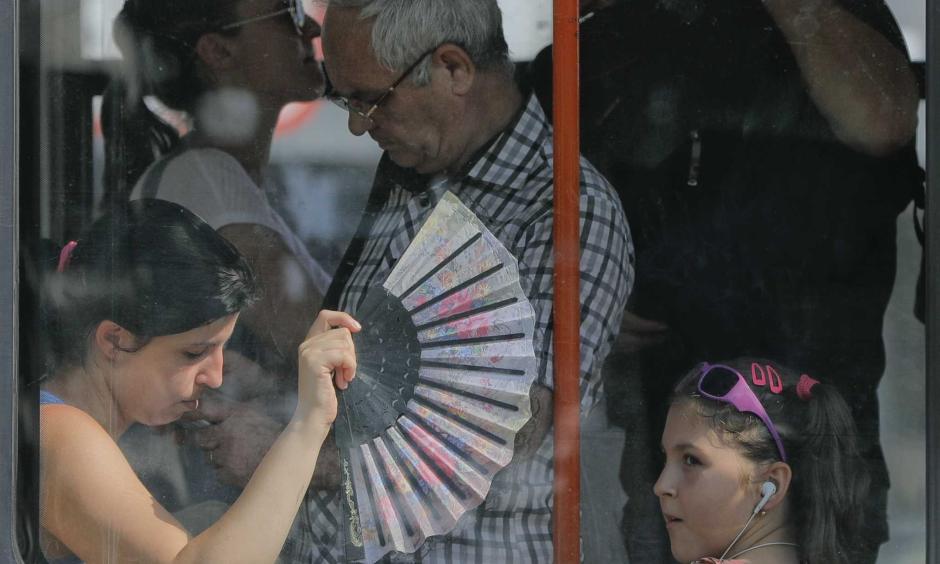 A woman uses a fan to cool herself and a child wile ridding on a tram in Bucharest, Romania, Friday, Aug. 4, 2017. Romanian meteorologists issued an extreme temperatures warning, with 42 Celsius (107.6 F) forecast for parts of western Romania and placing 12 counties under a "red code" heat alert for the next two days. Photo: Vadim Ghirda, AP
