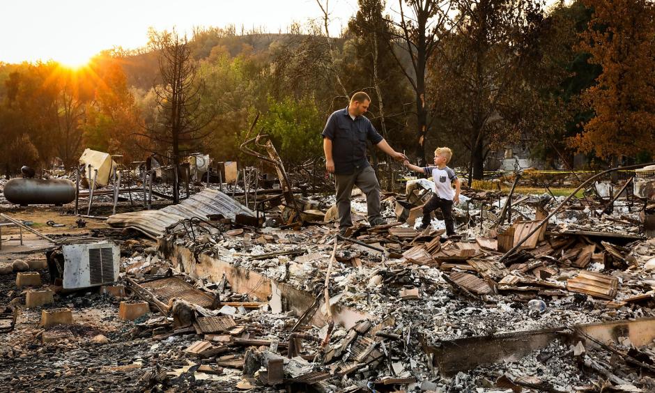 Five-year-old Daniel Wood shows his grandfather, Matthew Schjoth, a wrench he found as they look through the remains of their home on Harlan Drive in Redding that was destroyed in the Carr Fire. Credit: San Francisco Chronicle