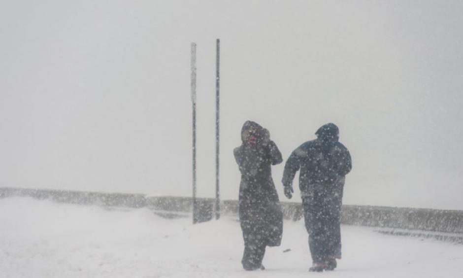Two people brave high speed winds Tuesday at Revere Beach. Photo: Ryan McBride, AFP, Getty Images