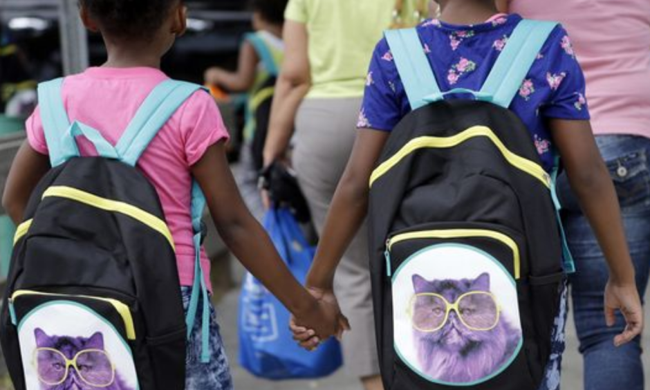 In this file photo, children in Miami hold hands as they walk with their new book bags. Photo: Lynne Sladky, AP