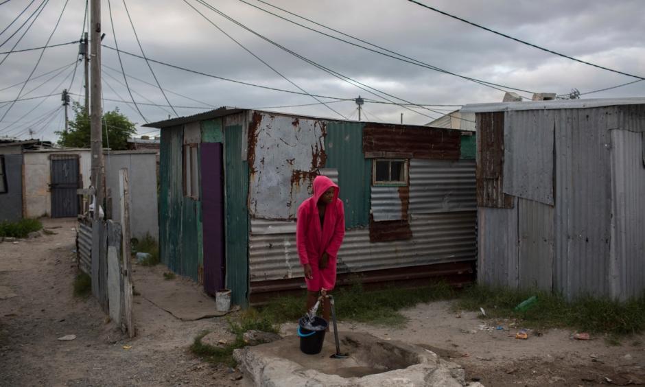 In this Feb. 2, 2018 photo, a woman collects water in a settlement near South Africa’s drought-hit city of Cape Town. About a quarter of Cape Town’s population lives in the informal settlements, where they get water from communal taps instead of individual taps at home like in the richer suburbs. And they use 4.5 percent of the total water consumption. Photo: Bram Janssen, AP