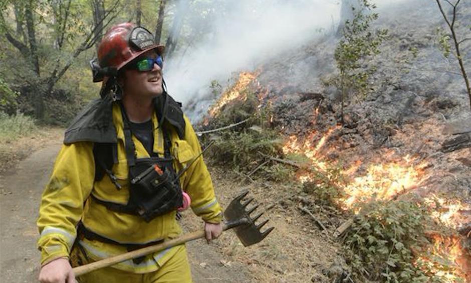 Rancho Adobe Fire Captan James Devrloo keeps an eye on a fire line on Garza Trail in the Rancho San Carlos Community as a wildfire burns in Carmel Valley, Calif. July 27, 2016. Photo: David Royal, The Monterey County Herald via AP