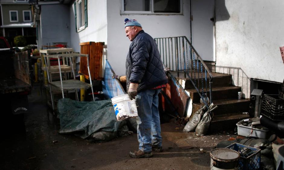 A man takes a break from cleaning out his home flooded by Superstorm Sandy in the Hudson River town of Piermont, New York, November 8, 2012. Photo: Mike Segar, Reuters