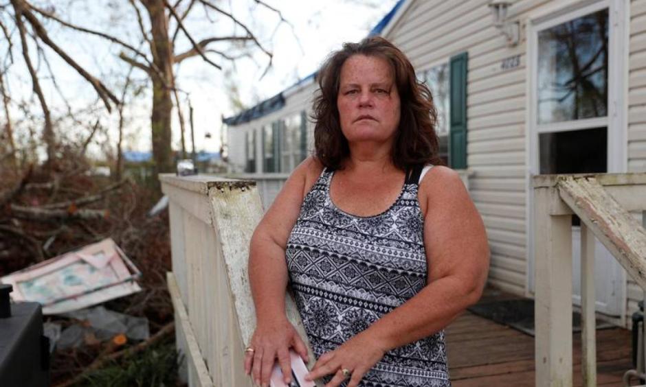 Melissa Hutchinson, 51, poses for a portrait near debris from Hurricane Michael outside her home in Panama City, Florida, U.S., November 5, 2018. Photo: Terray Sylvester, Reuters