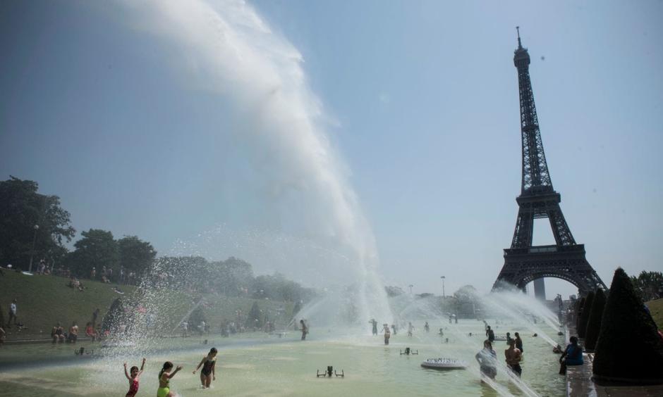 Cooling down at the fountains of Trocadero, near the Eiffel Tower, on a day of record heat in Paris on July 25. Photo: Julien De Rosa, EPA-EFE/Shutterstock
