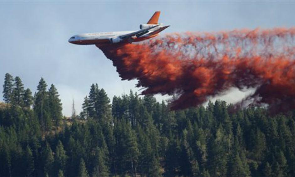 A DC-10 tanker airplane drops fire retardant on a wildfire north of Twisp, Wash. Friday, Aug. 21, 2015. (AP Photo/Ted S. Warren)
