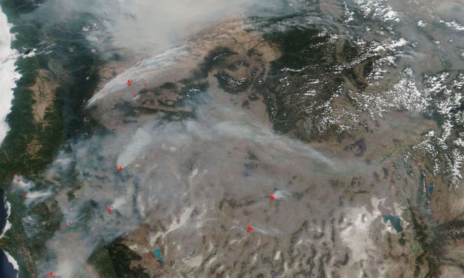A satellite image of smoke from wildfires in the Pacific Northwest in August 2018, with active fires labeled in red. Image: NASA