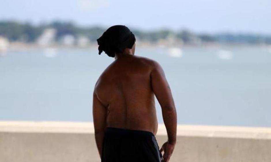 A man took to the shade at Wollaston Beach in Quincy on what promised to be a hot summer day Thursday morning. Photo: Jonathan Wiggs, Globe Staff