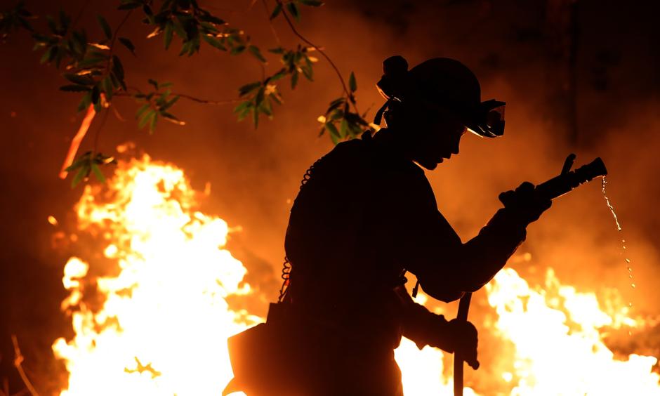 Cal Fire firefighter Trevor Smith battles the Tubbs Fire near Calistoga, Calif., on Thursday. Wildfires in Northern California have killed dozens of people and destroyed thousands of homes and businesses. Credit: Justin Sullivan, Getty Images