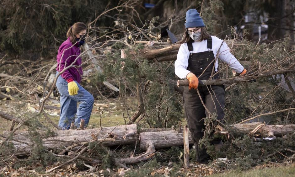 Residents clear fallen trees Thursday, after a strong storm swept through Hartland, Minn. A powerful storm system swept across the Great Plains and Midwest, bringing hurricane-force wind gusts and spawning reported tornadoes in Nebraska, Iowa and Minnesota. (Credit: Christian Monterrosa/AP)