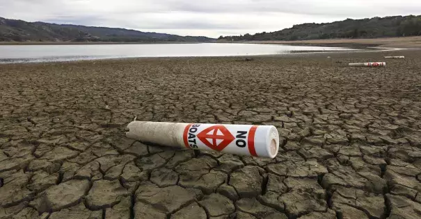 In this Feb. 4 2014 file photo, a warning buoy sits on the dry, cracked bed of Lake Mendocino near Ukiah, California. Photo: Rich Pedroncelli, AP
