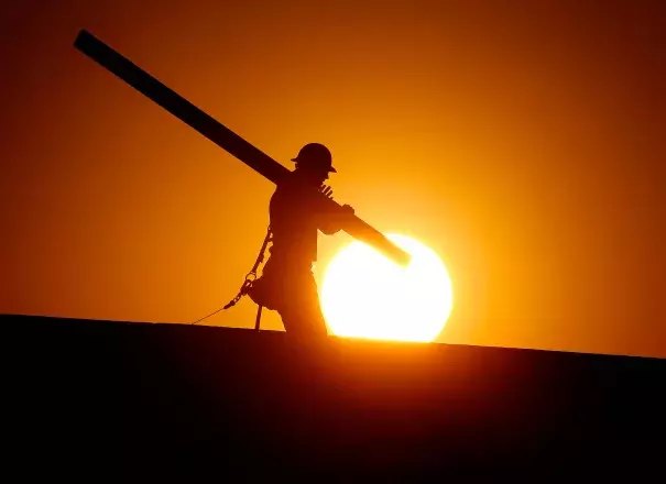 A home builder works at sunrise on Monday, June 20, in Gilbert, Arizona, in an effort to beat the rising temperatures. Photo: Matt York / AP