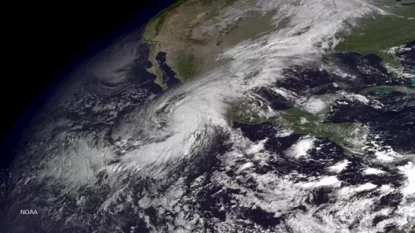 A handout satellite image made at 10:45 am ET and released by the US National Oceanic and Atmospheric Administration (NOAA) on 23 Oct. 2015 shows Hurricane Patricia (L) as it approaches the coastline of Mexico from the Eastern Pacific. Image: EPA / NOAA / HANDOUT