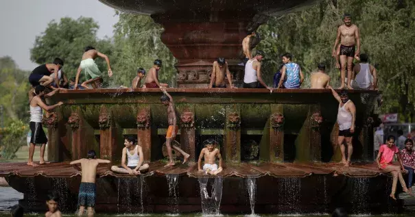People cooling off at a fountain near the India Gate monument in New Delhi on Tuesday. Photo: Altaf Qadri, Associated Press