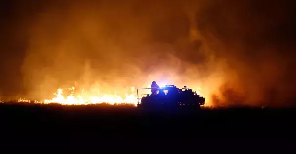 Firefighters near Protection, Kan., this week. Dry conditions have helped fuel the flames. Photo: Credit Bo Rader, The Wichita Eagle, via Associated Press