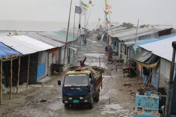 A man on the back of a mini truck waves to camera as he leaves after evacuating valuables on the Bay of Bengal coast secure their boats anticipating a storm in Patenga, Chittagong, Monday, Oct.24, 2022. Authorities in Bangladesh were evacuating hundreds of thousands of people across its vast coastal region on Monday as a tropical storm quickly approached amid fears of extensive damage. (Credit: AP Photo)