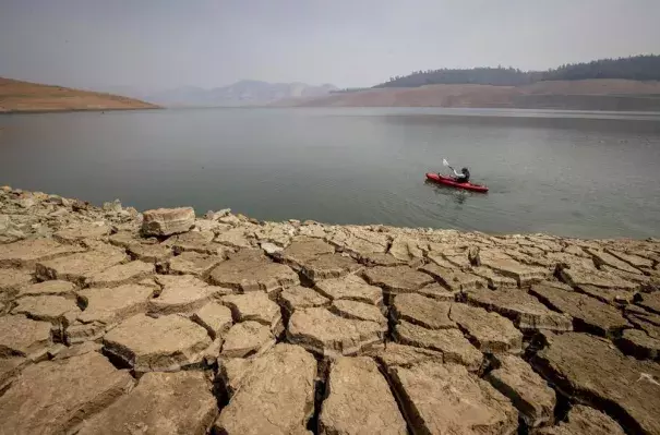 A kayaker paddles in Lake Oroville as water levels remain low due to continuing drought conditions in Oroville, Calif., on Aug. 22, 2021. The American West's megadrought deepened so much last year that it is now the driest it has been in at least 1200 years and a worst-case scenario playing out live, a new study finds. (Credit: AP Photo/Ethan Swope, File)