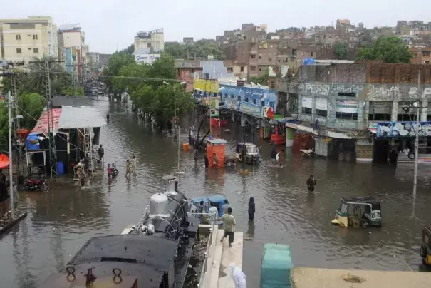 People navigate through flooded roads after heavy monsoon rains, in Hyderabad, Pakistan, Wednesday, Aug. 24, 2022. Heavy rains have triggered flash floods and wreaked havoc across much of Pakistan since mid-June, leaving 903 dead and about 50,000 people homeless, the country's disaster agency said Wednesday. (Credit: AP Photo/Pervez Masih)