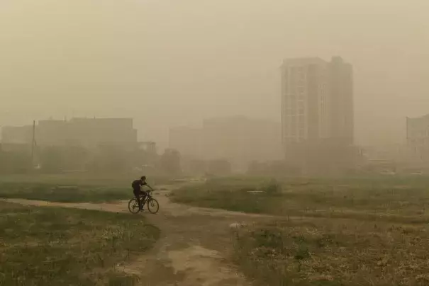 A man rides his bicycle through smoke from a forest fire covers Yakutsk, the capital of the republic of Sakha also known as Yakutia, Russia Far East, Russia, Thursday, Aug. 12, 2021. The U.N. weather agency has certified a 38-degree Celsius (100.4 Fahrenheit) reading in the Russian town of Verkhoyansk last year as the highest temperature ever recorded in the Arctic. The World Meteorological Organization said the temperature "more befitting the Mediterranean than the Arctic" was recorded in June 2020 during