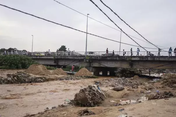 Belongings and debris are washed up by a bridge as residents clean up following torrential rains in Kinshasa,Democratic Republic of Congo Tuesday Dec. 13, 2022. At least 100 people have been killed and dozens injured by widespread floods and landslides caused by the rains. (Credit: AP Photo/Samy Ntumba Shambuyi)