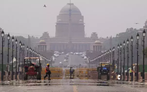 A construction worker walks across a mirage created on a road following a heat weave, in New Delhi, Monday, May 2, 2022. The intense heat wave sweeping through South Asia was made more likely due to climate change and it is a sign of things to come. An analysis by international scientists said that this heat wave was made 30-times more likely because of climate change, and future warming would make heat waves more common and hotter in the future.(Credit: AP Photo/Manish Swarup)