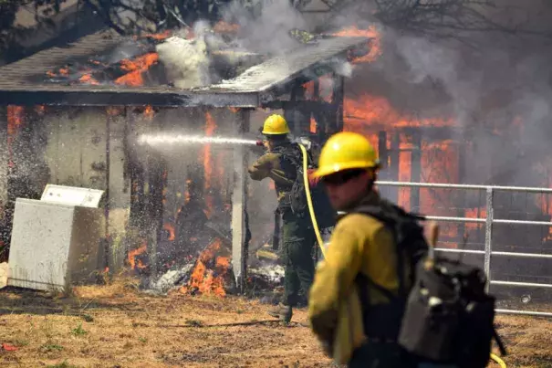 Firefighters battle flames as a house burns in Lower Lake, Calif., in August 2016. Photo: Josh Edelson, AP