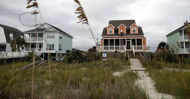 Workers install window shutters at an oceanfront home in anticipation of Hurricane Matthew in Garden City Beach, S.C., U.S. Oct. 5, 2016. Photo: Randall Hill